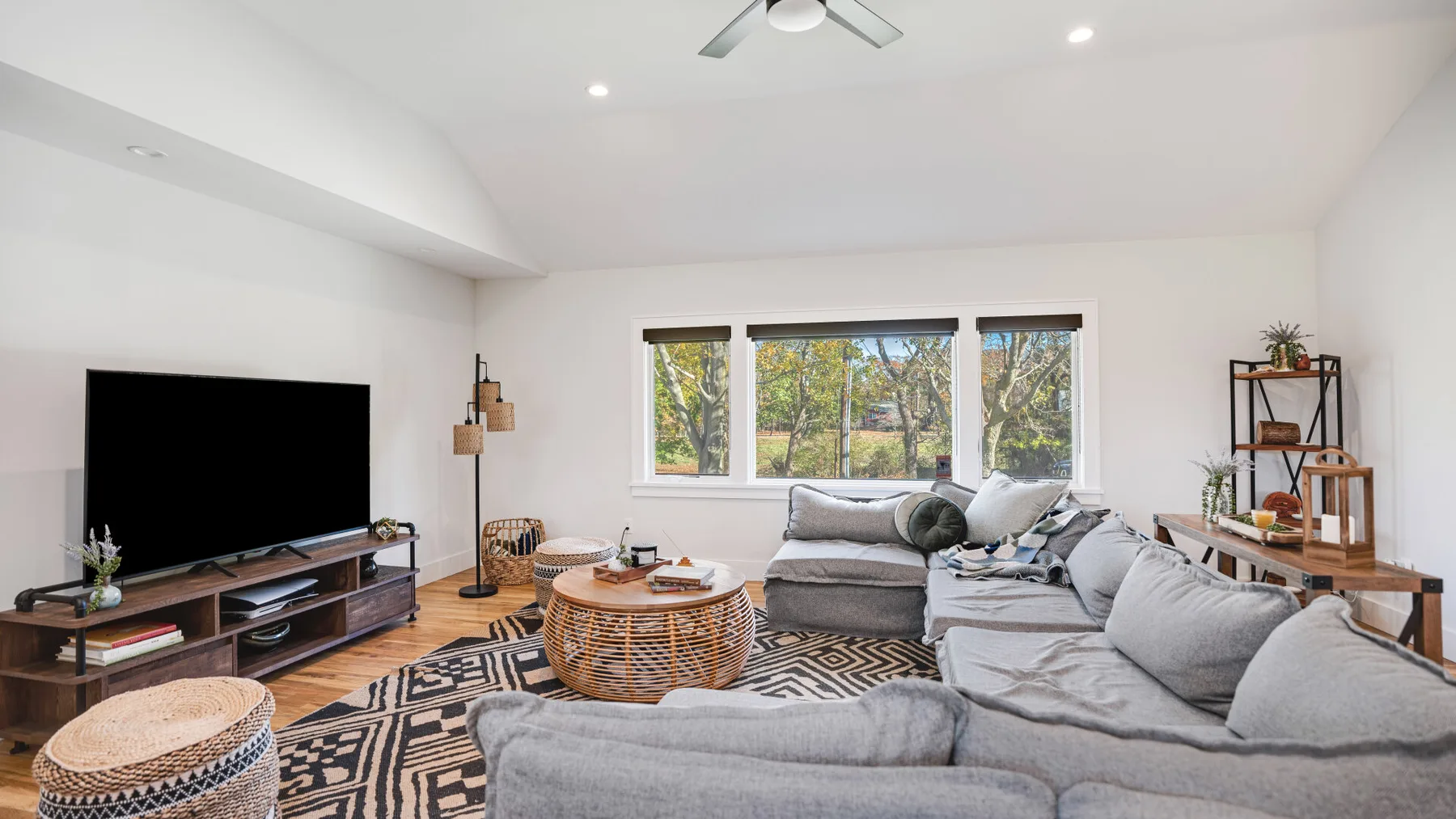 A bright living room with a sectional seating area and a television.