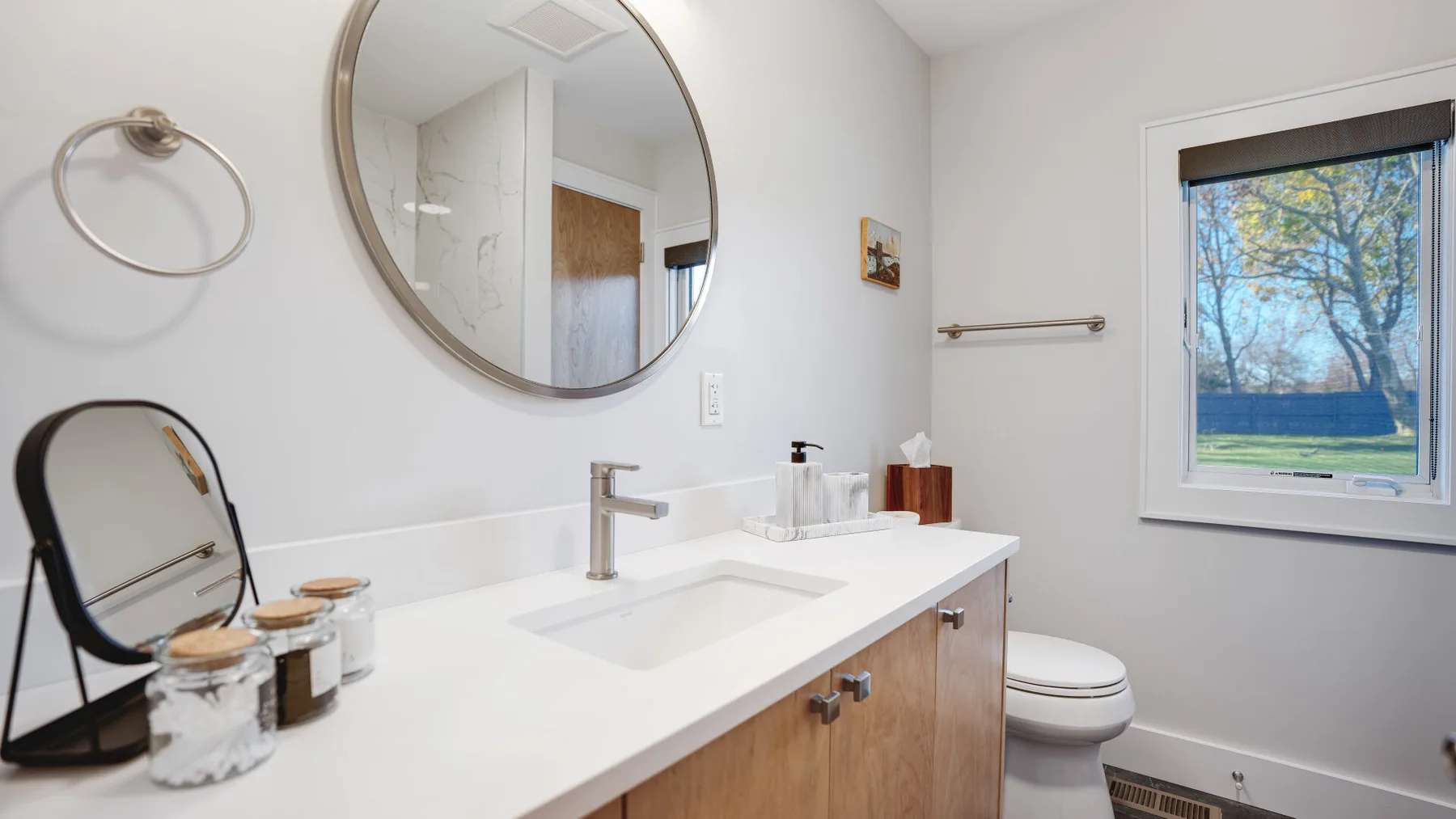 Un baño luminoso con un lavabo blanco y una ventana.