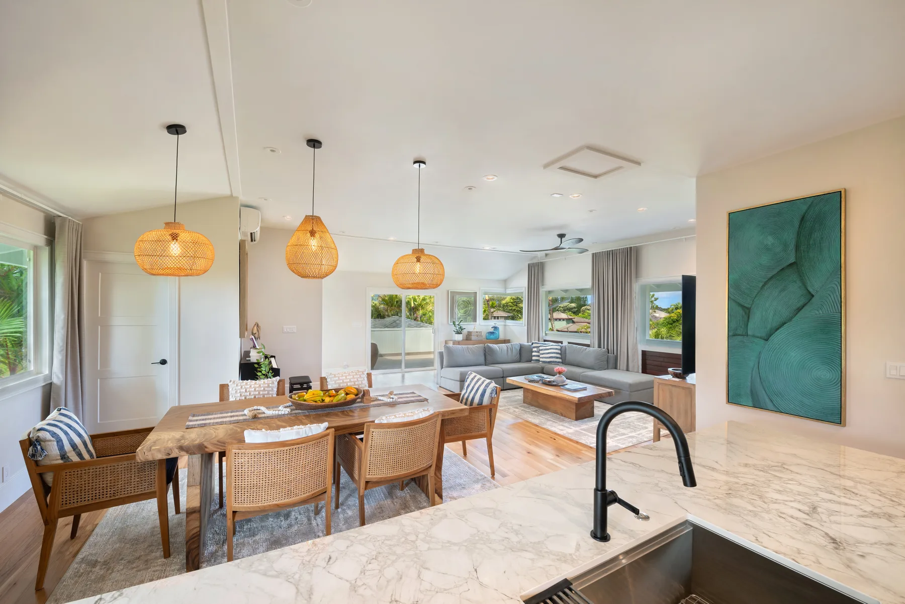 Sala y comedor de concepto abierto con isla de cocina y ventanales.