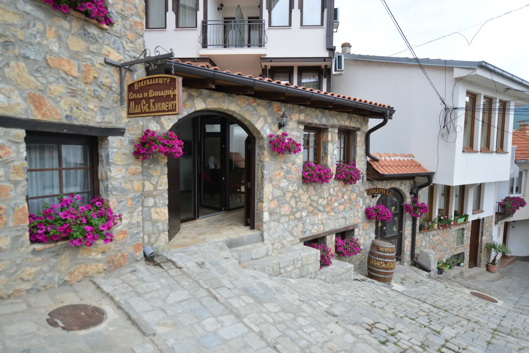 Entrada de la villa con un letrero y jardineras en las ventanas