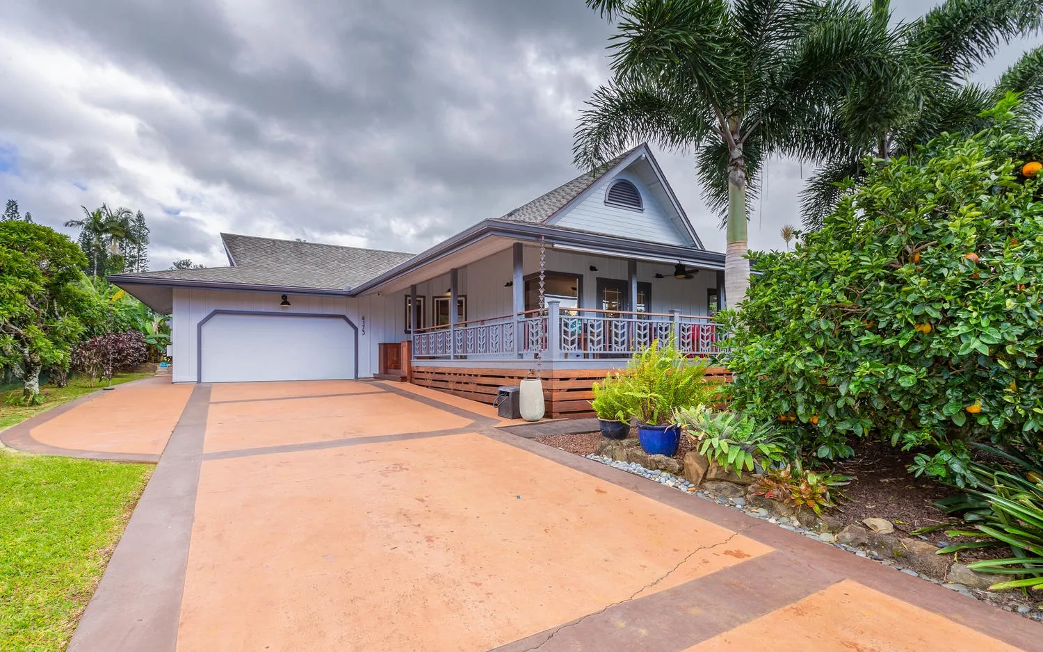 A house with a broad driveway, garage, and covered front porch.