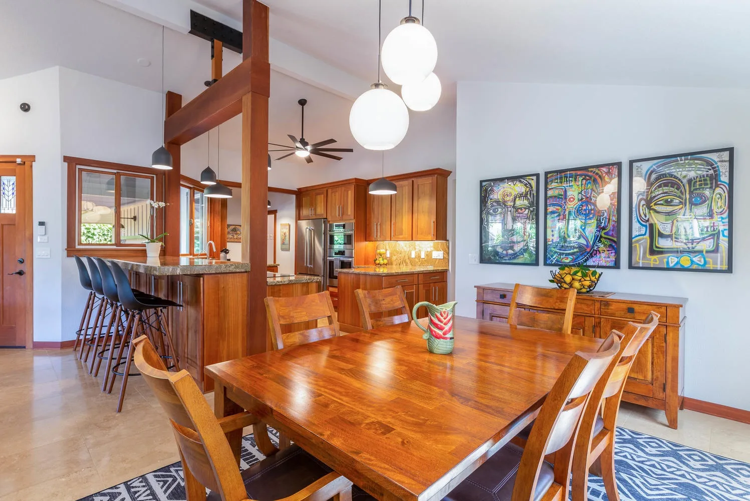 A dining area with a wooden table and colorful artwork on the wall.