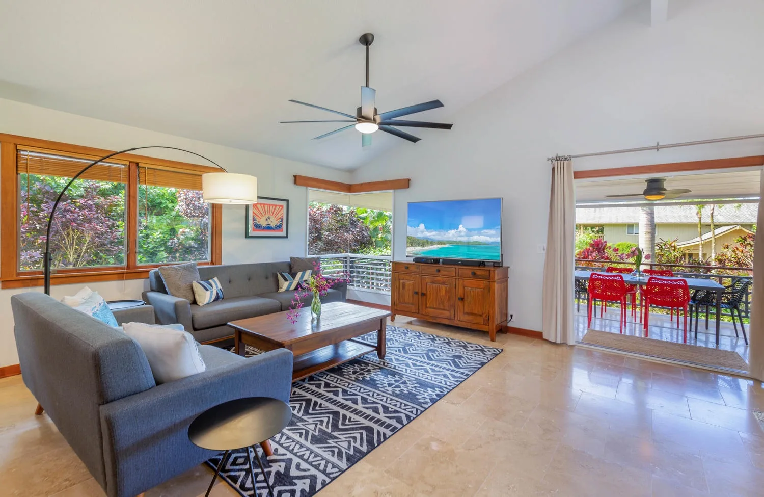 A living room with gray seating, a wooden coffee table, and a sliding glass door.