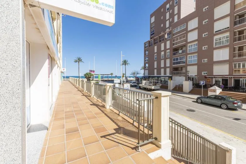 A tiled outdoor walkway overlooks a street and nearby buildings.