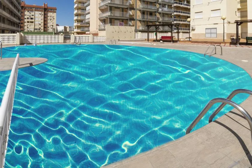 An outdoor swimming pool surrounded by apartment buildings.