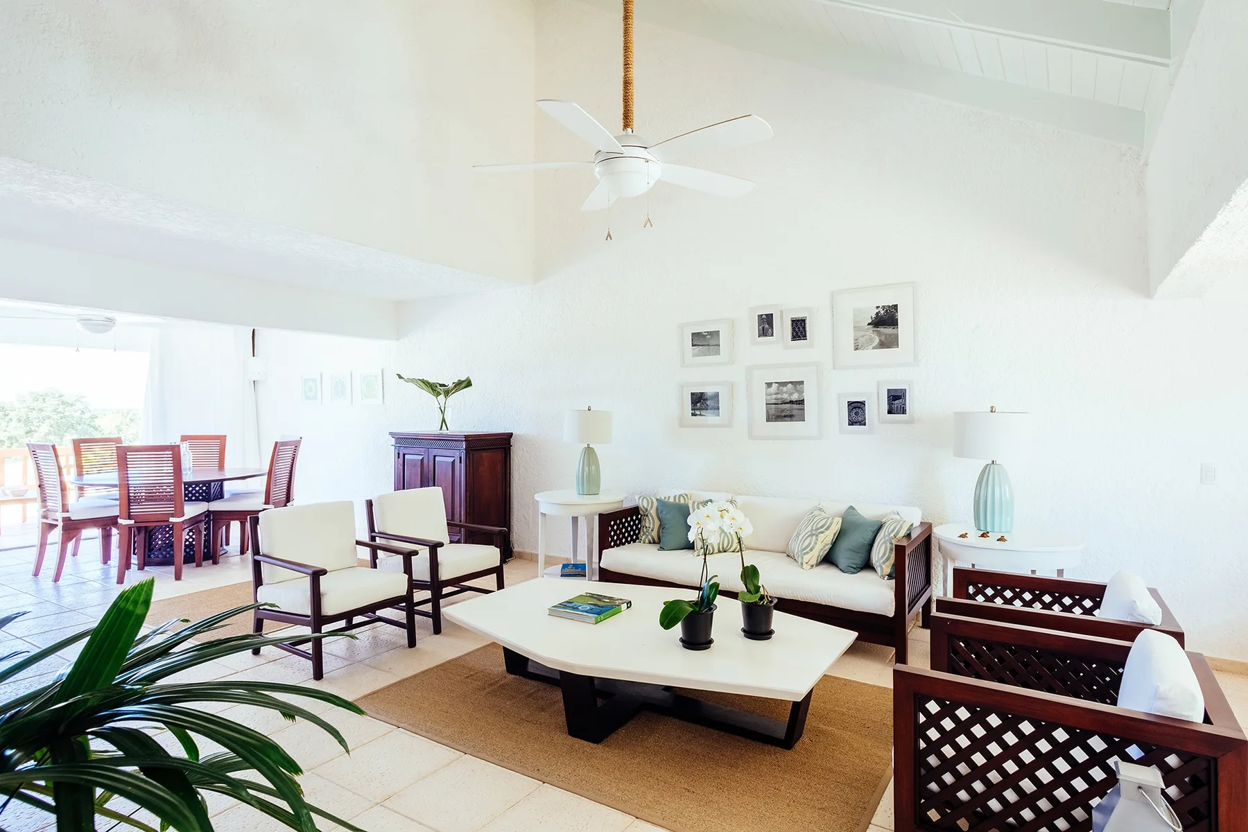 A bright living room with seating, a coffee table, and framed artwork.