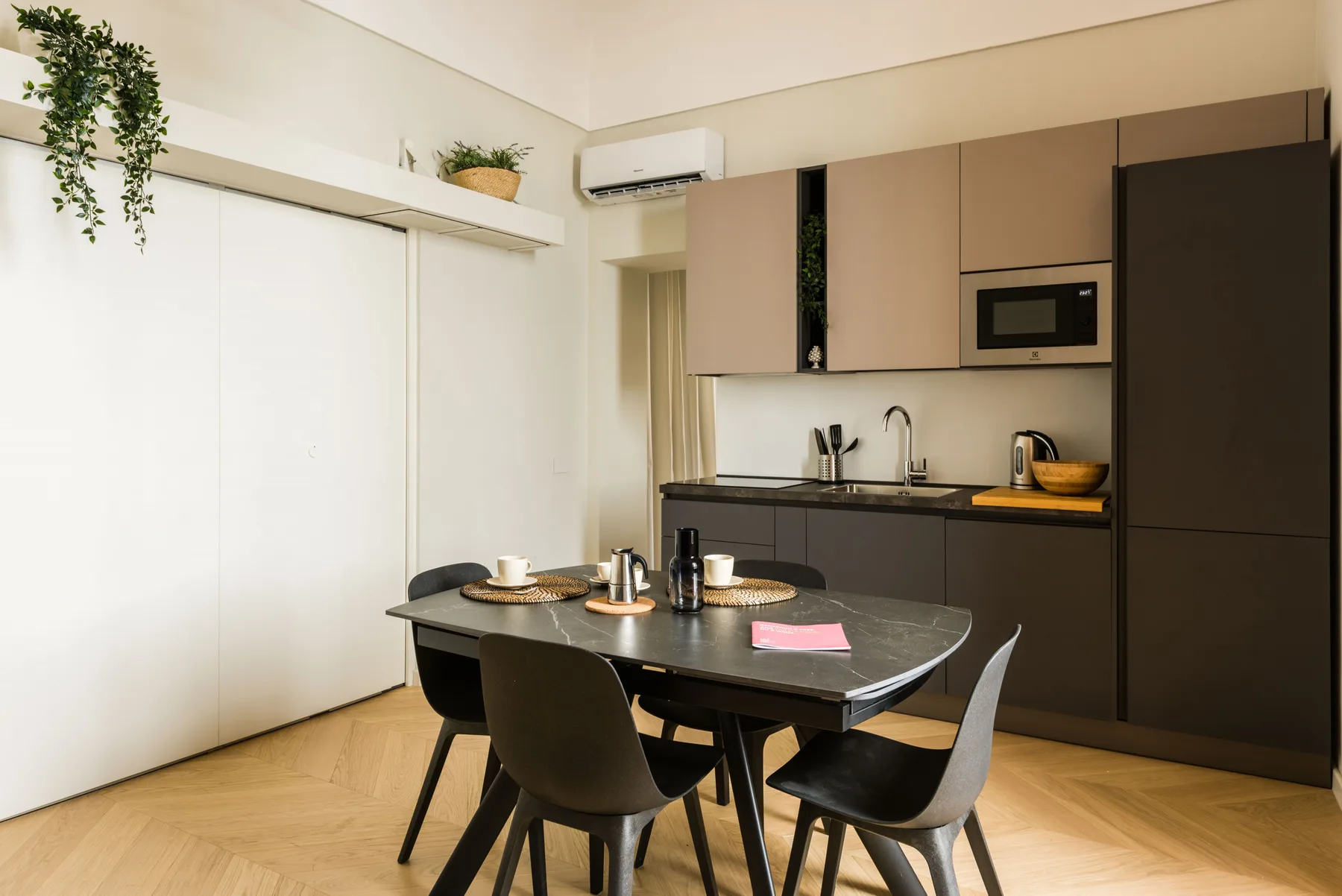 Comedor con mesa y sillas junto a una cocina compacta.