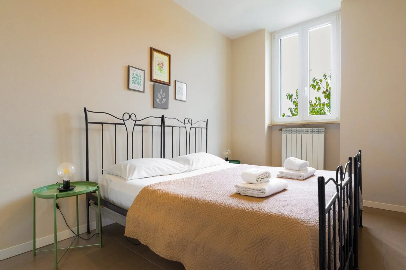 Un dormitorio con una cama bien arreglada y una ventana grande.