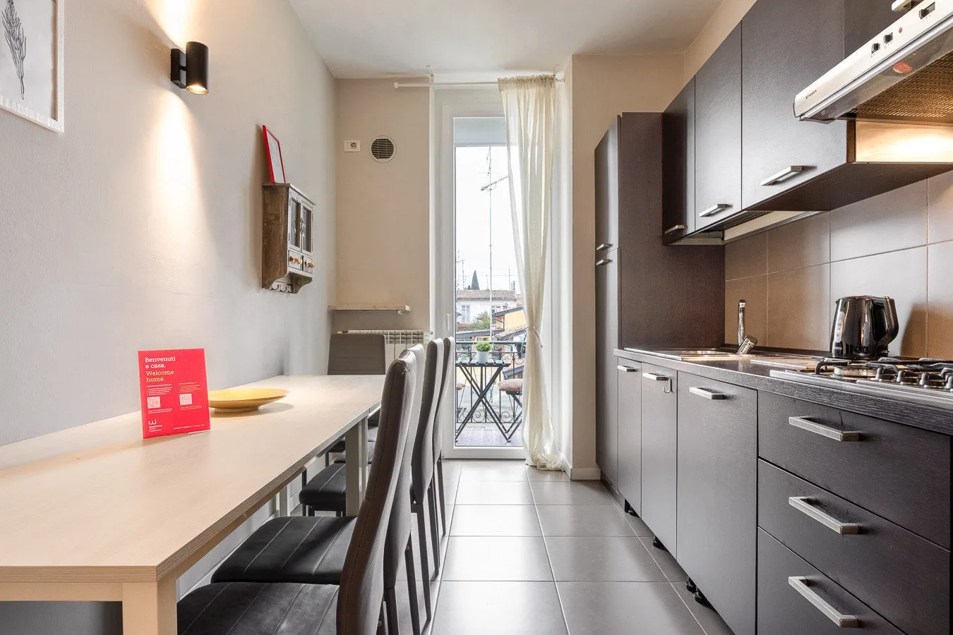 Comedor junto a una cocina compacta, con una mesa y armarios.