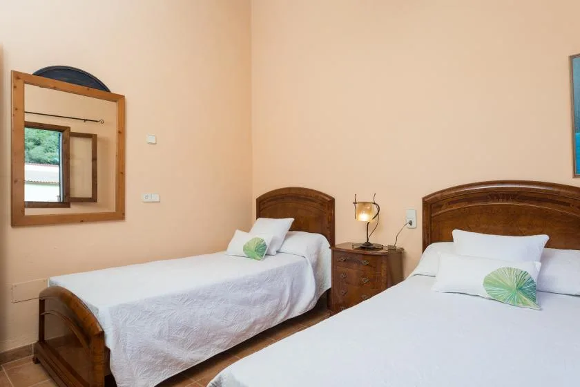 A bedroom with two beds and wooden headboards.
