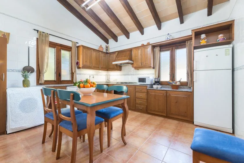 A kitchen and dining area with wooden cabinets and a table surrounded by seating.
