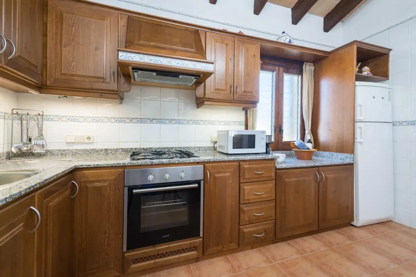 A kitchen with wooden cabinets, a countertop, and built-in appliances.