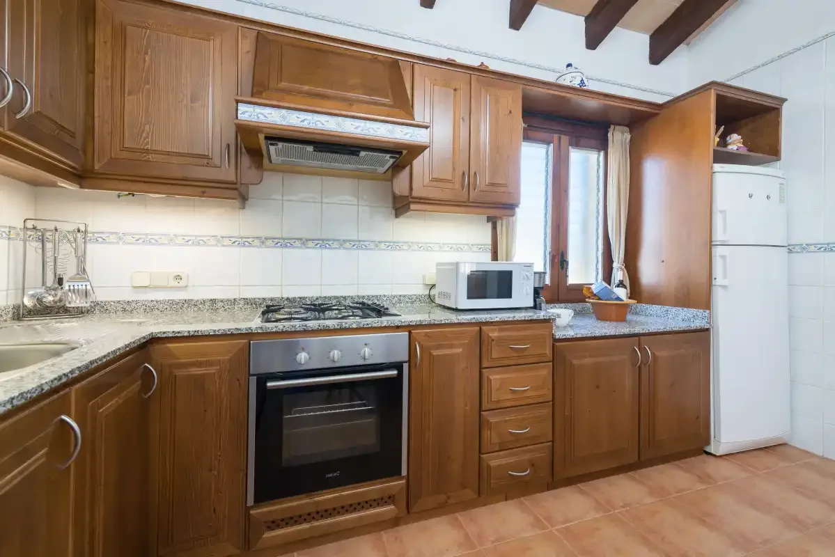 A kitchen with wooden cabinets, a countertop, and a built-in oven.