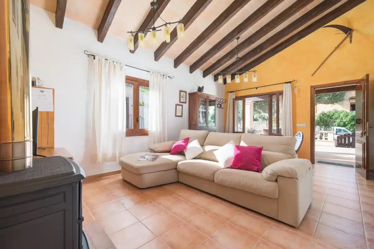 A living room with a sectional sofa and bright pink cushions.