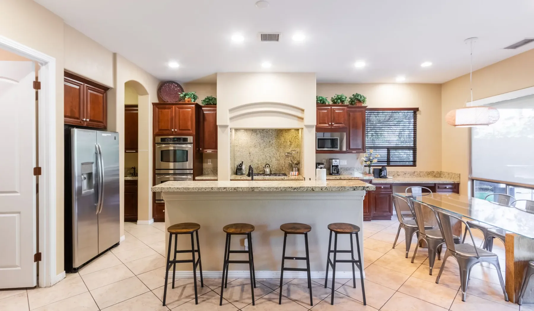 A spacious kitchen with a central island, bar seating, and a dining area.