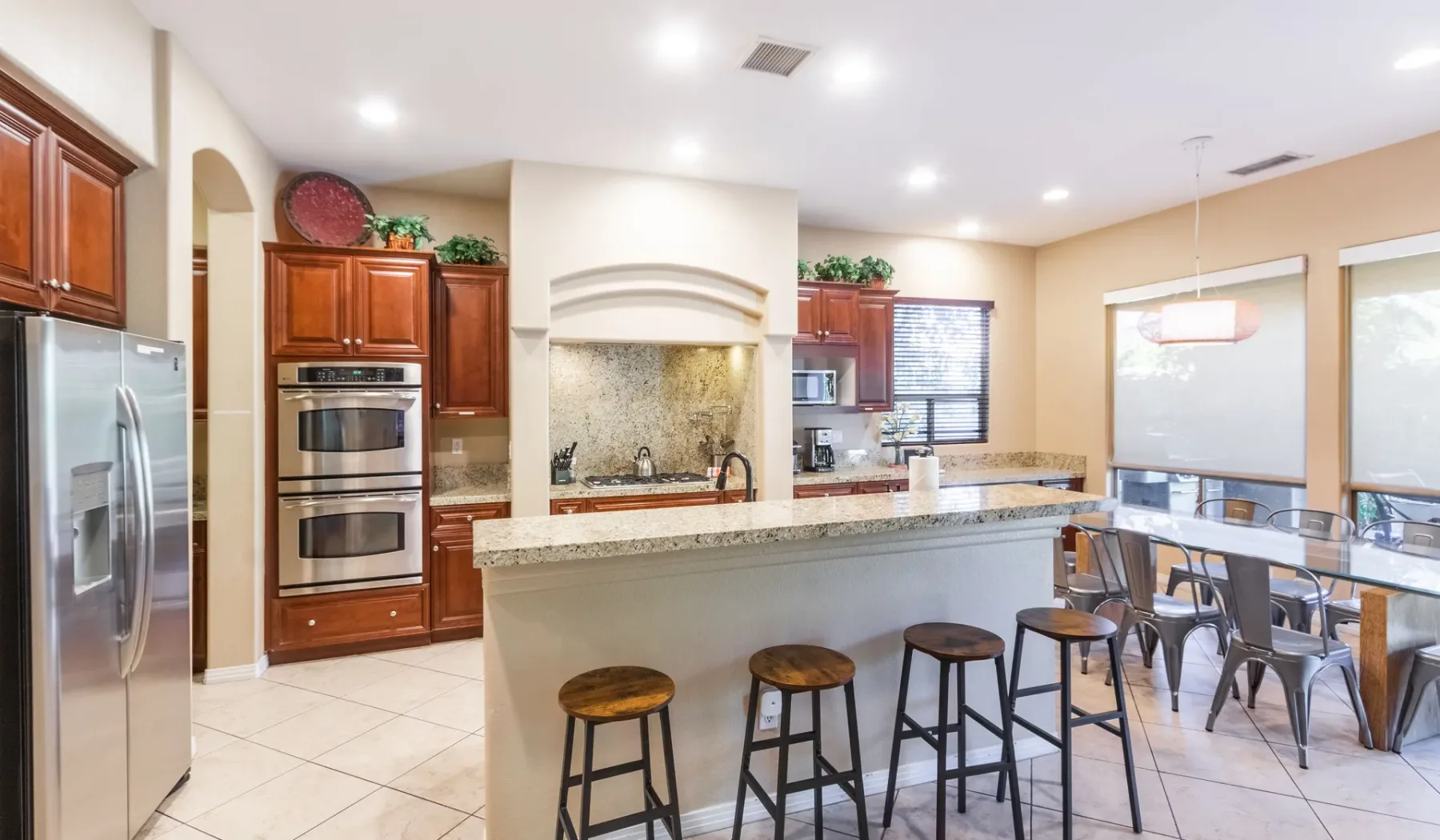 A bright kitchen with a breakfast bar and dining table.