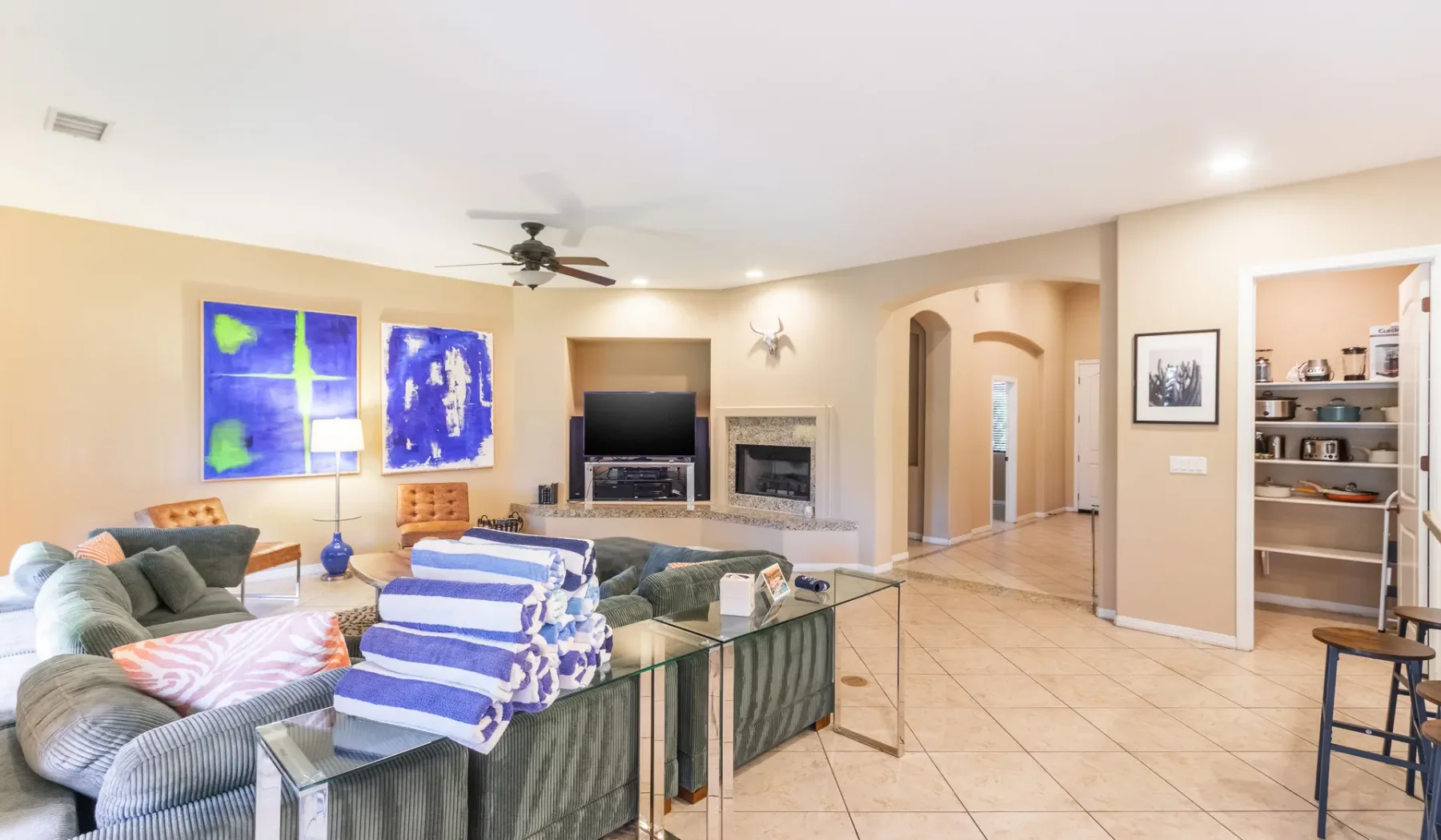 A spacious living room with seating, a television, and a fireplace.