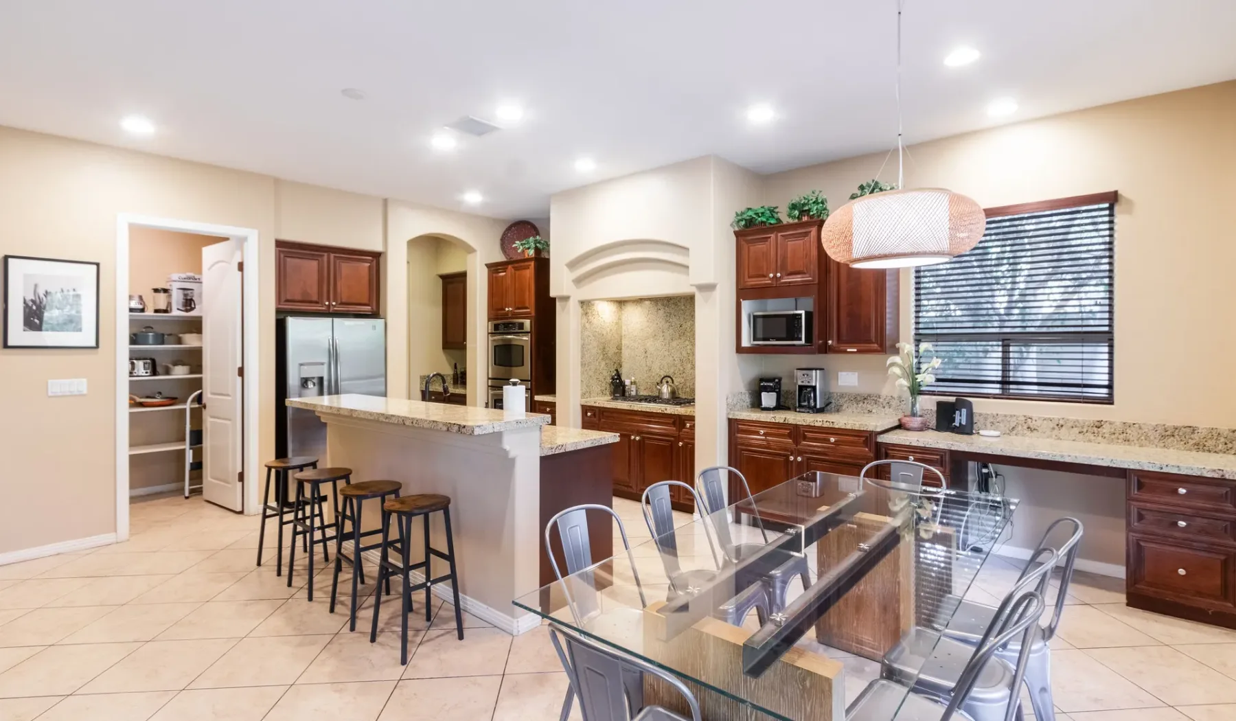 A spacious kitchen with a central island, bar seating, and a dining table.