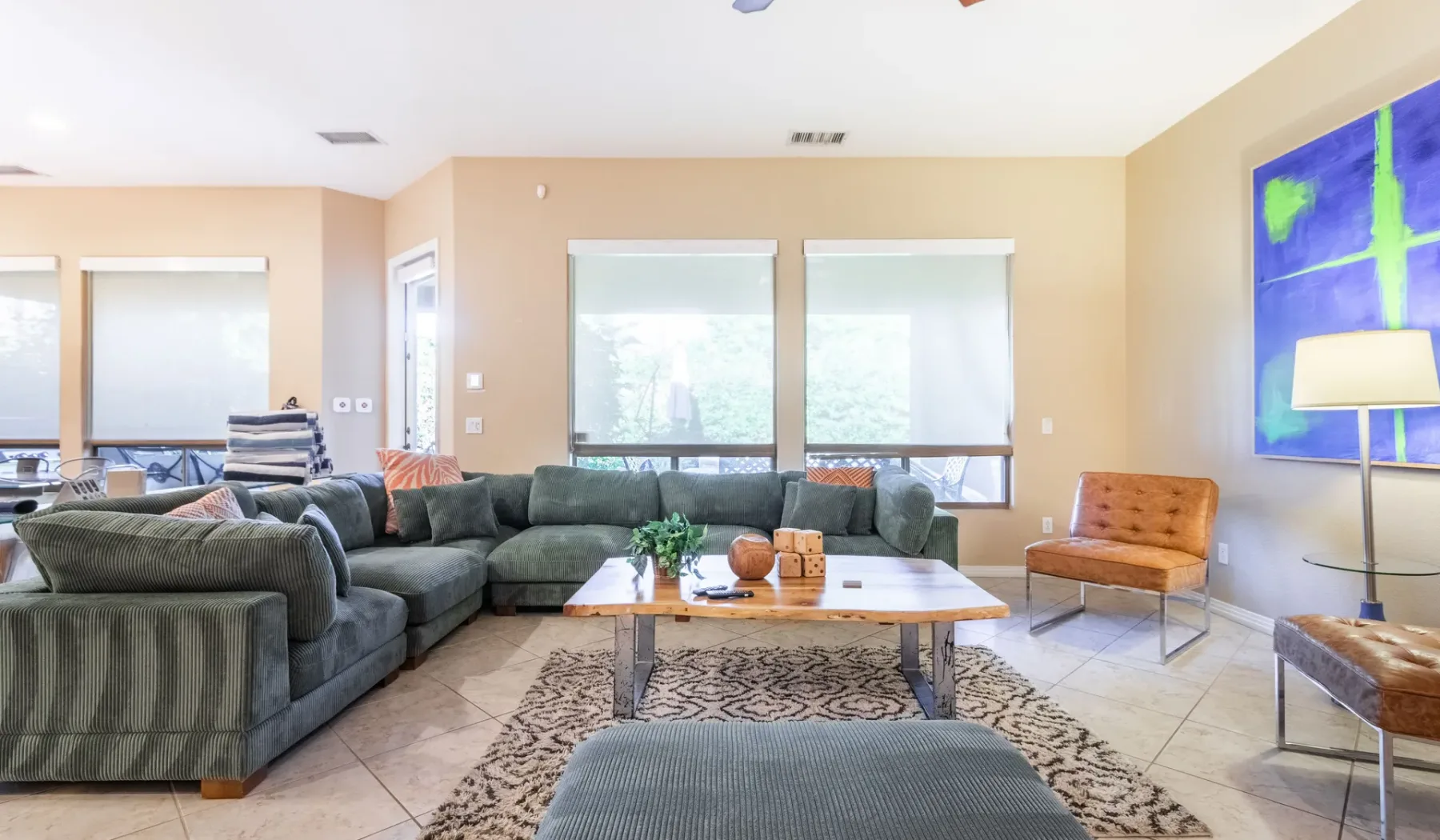 A living room with sectional seating, a coffee table, and large windows.