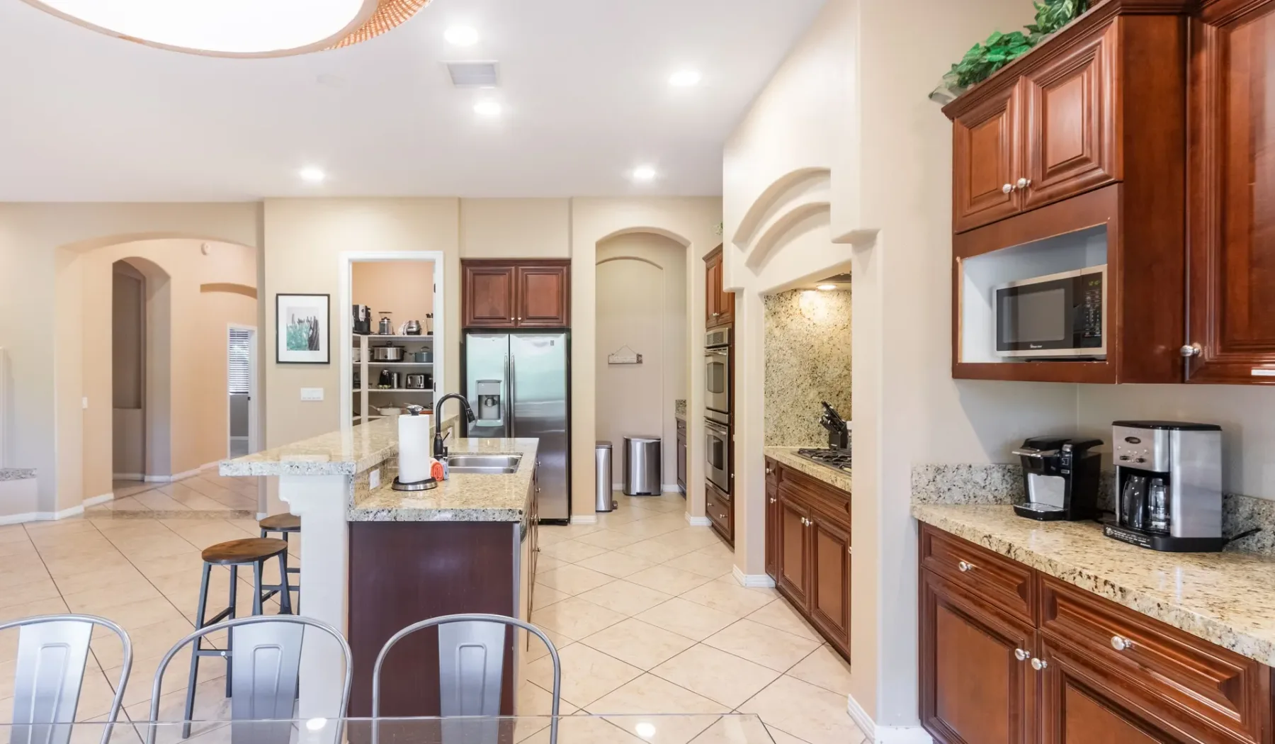 A spacious kitchen with wood cabinets, granite counters, and a central island.