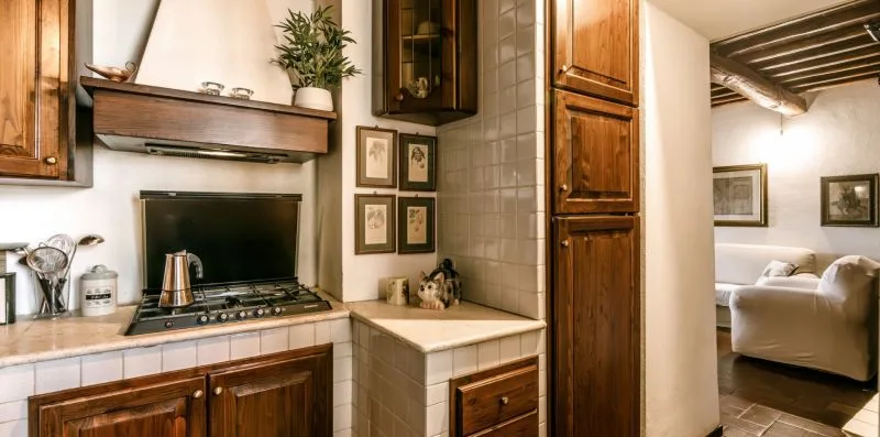 A tiled kitchen counter and stove sit beside a doorway to a living area.
