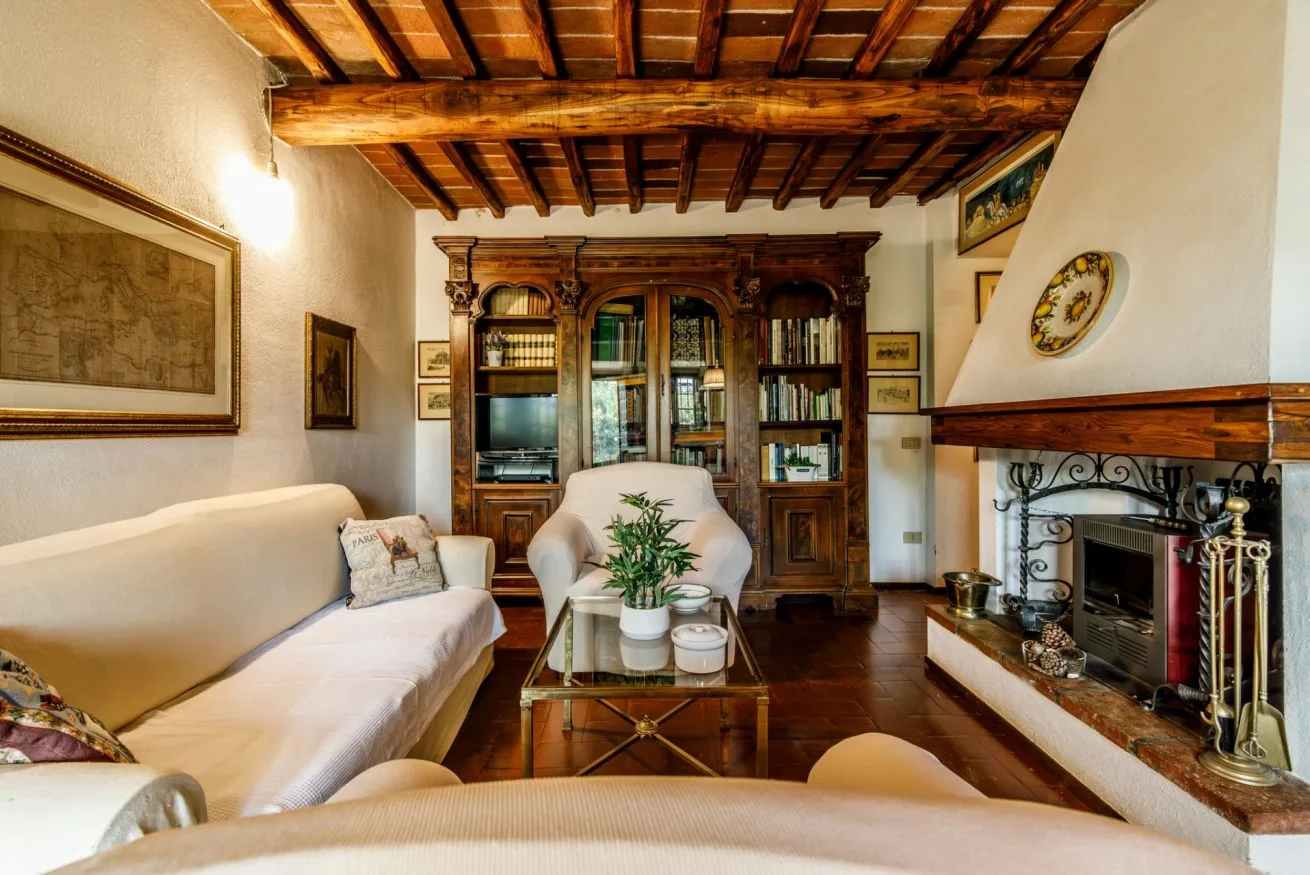 A living room with seating, a wooden bookcase, and a fireplace.