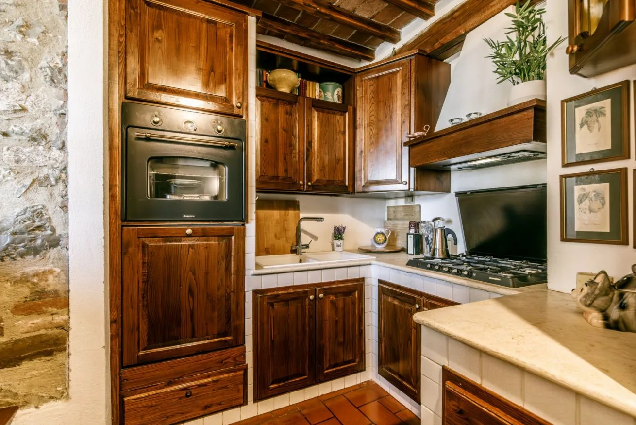A rustic kitchen with wooden cabinetry, a built-in oven, and a cooktop.