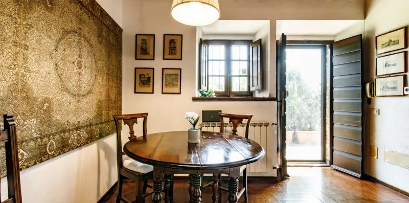 A dining area with a round table beside an open glass door.