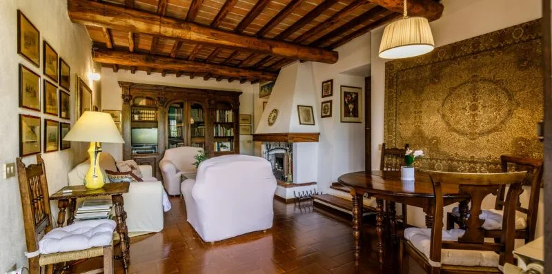 A living room with upholstered seating, a fireplace, and a dining table.