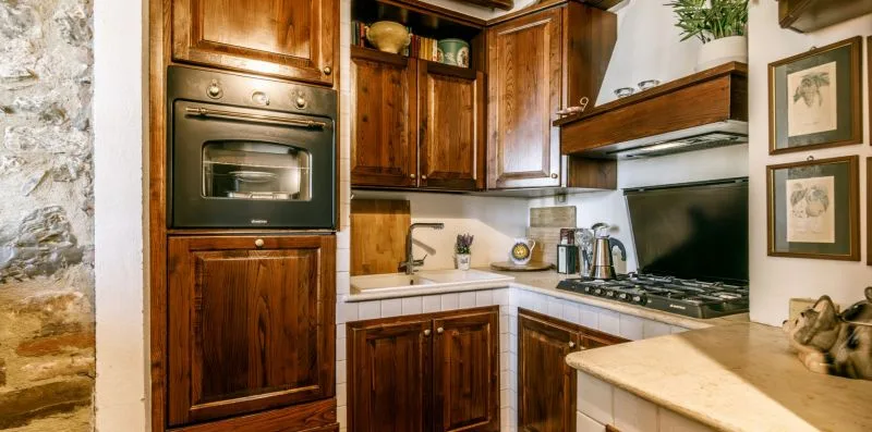 A kitchen with wooden cabinets, a built-in oven, and a cooktop.