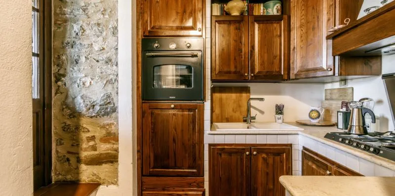 A compact kitchen with wooden cabinets and light-colored countertops.
