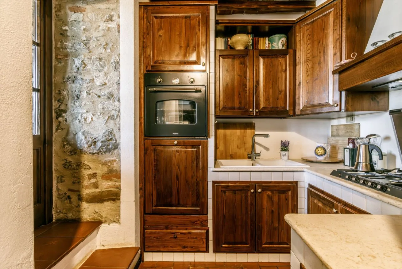 A kitchen with wooden cabinets, a built-in oven, and a countertop.