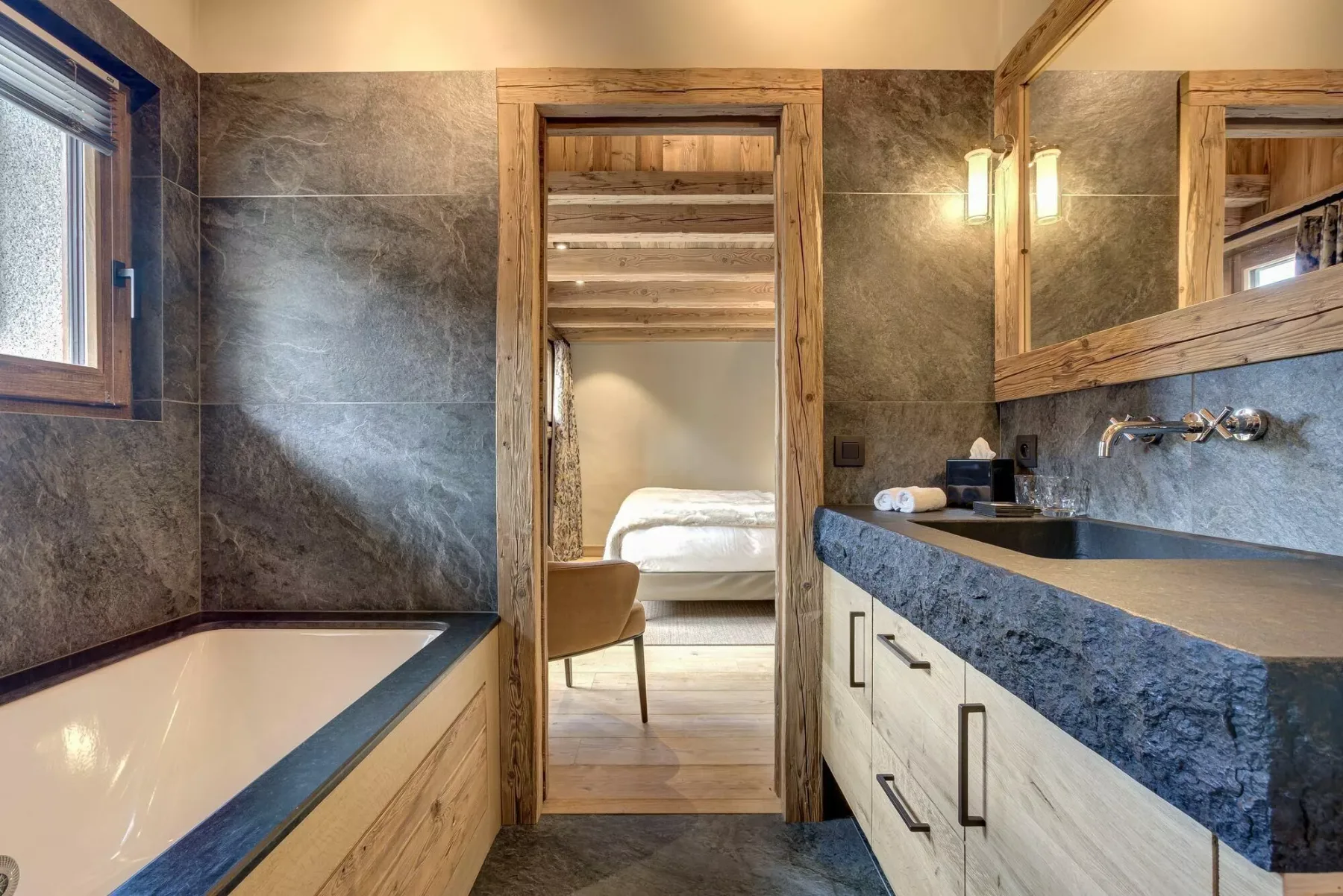 Un baño con bañera y un largo tocador junto a una puerta abierta.
