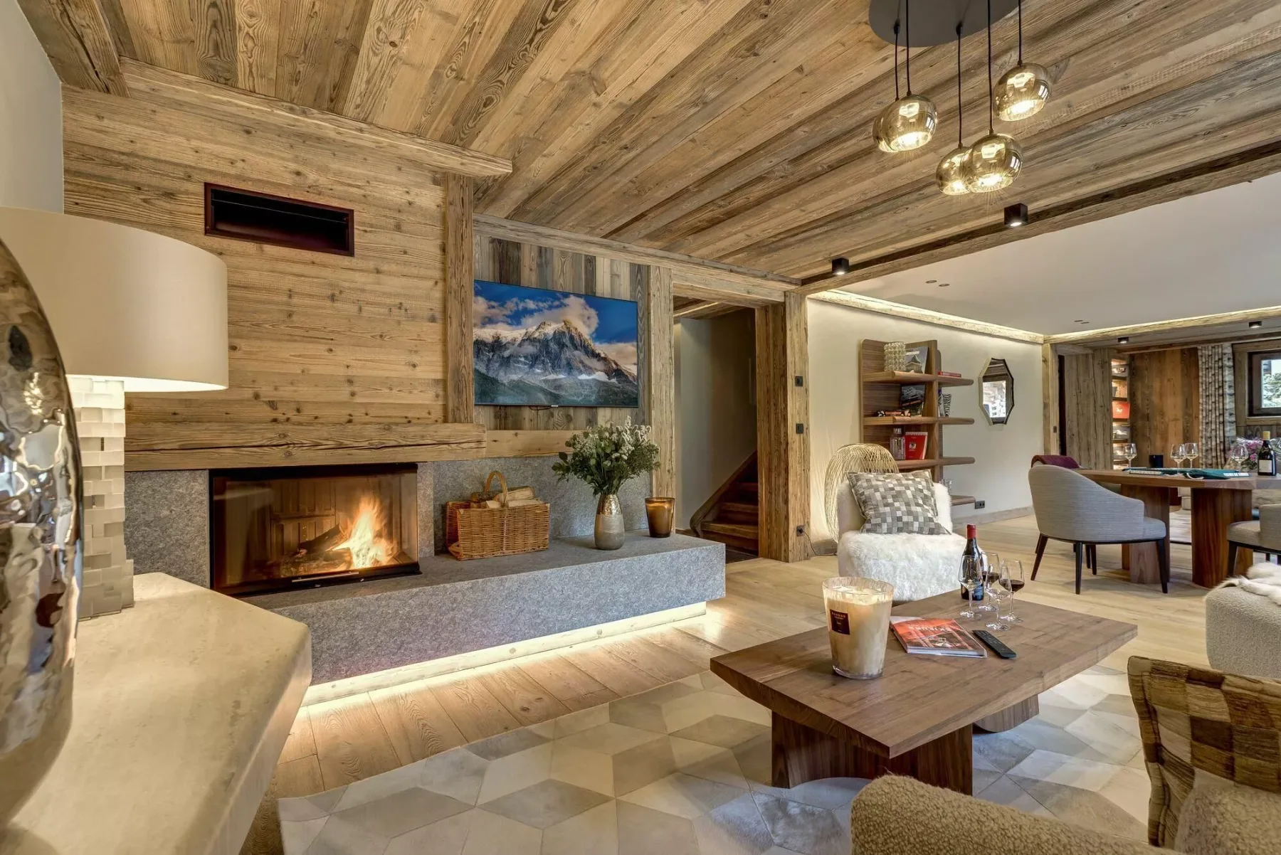 Una sala de estar rústica con chimenea, asientos y comedor.