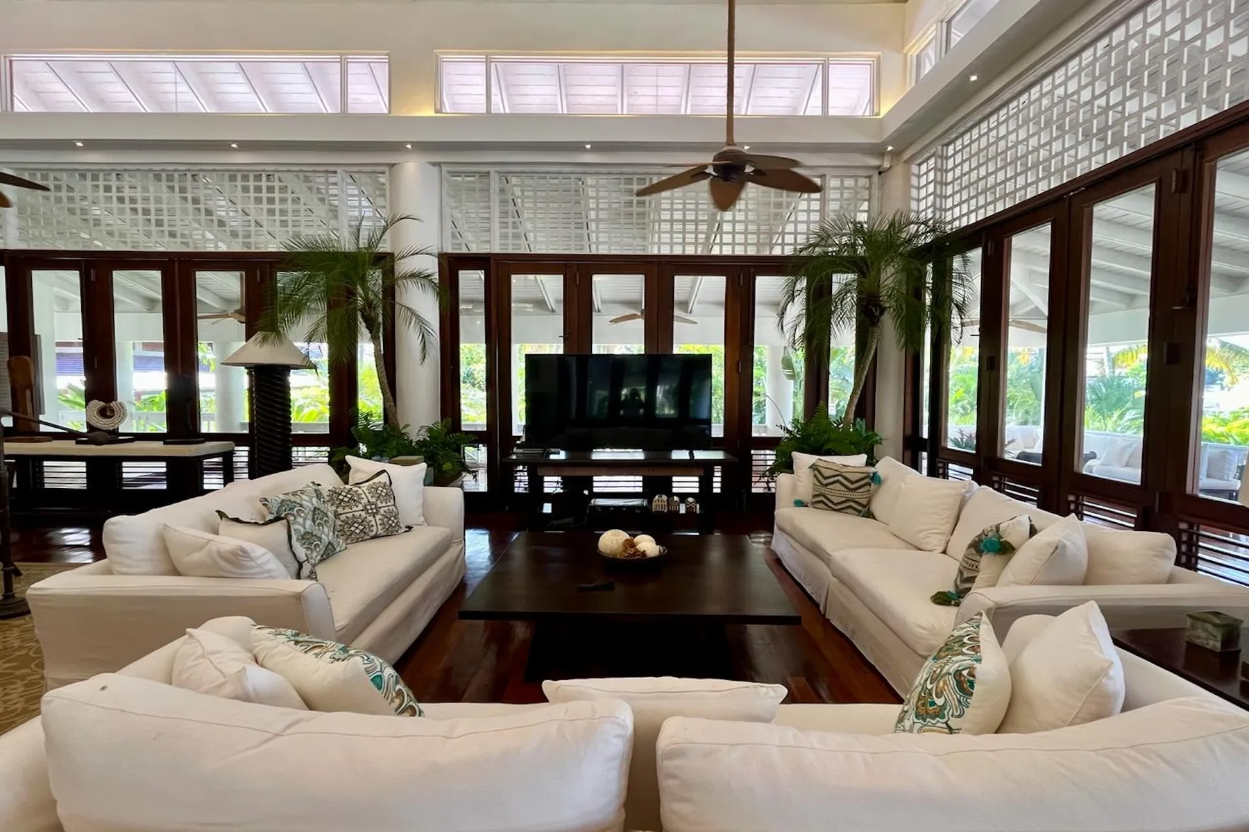 A bright living room with seating arranged around a television and low table.