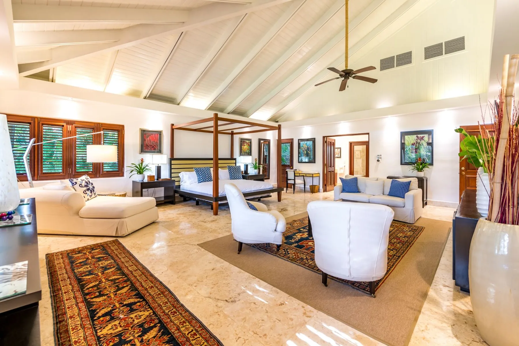 A spacious living room with seating arranged around patterned rugs.