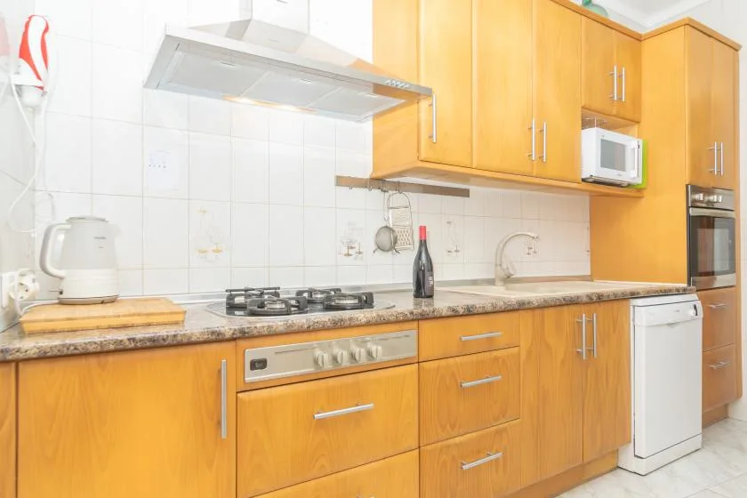 A kitchen with wooden cabinets, a stovetop, and a countertop.