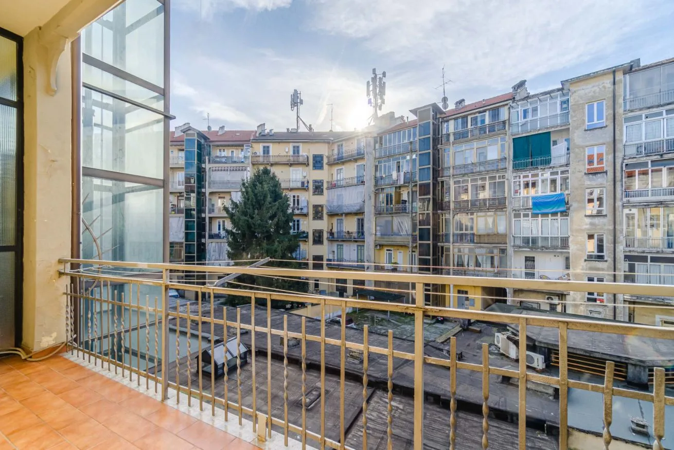 Un balcón da a un patio rodeado de edificios de apartamentos.