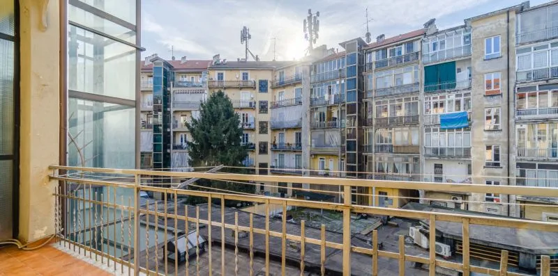 Un balcón da a un patio rodeado de edificios de apartamentos.