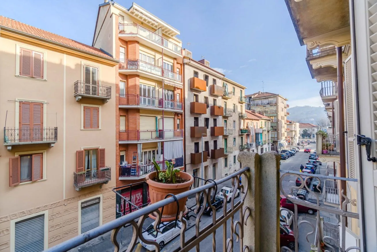 Un balcón da a una calle residencial flanqueada por edificios de apartamentos.