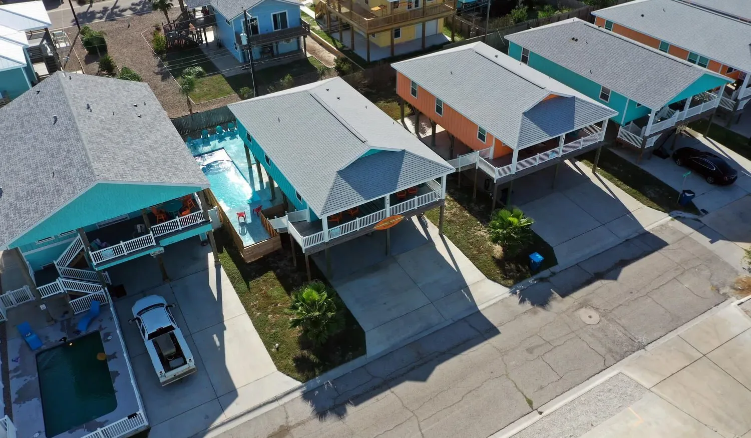 An aerial view of a row of colorful houses along a residential street.
