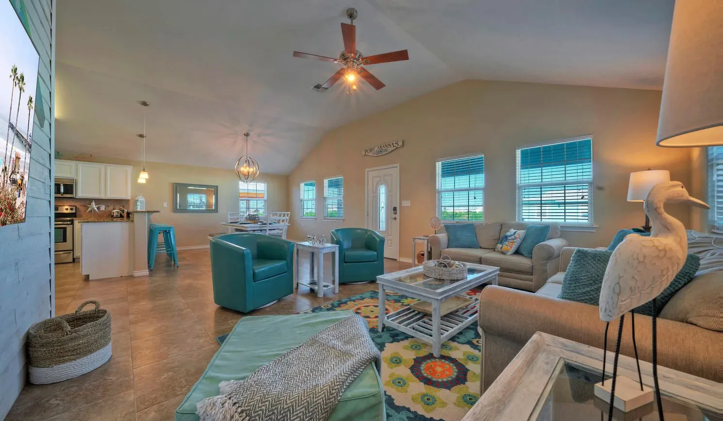A spacious living room with seating, a coffee table, and an open kitchen.