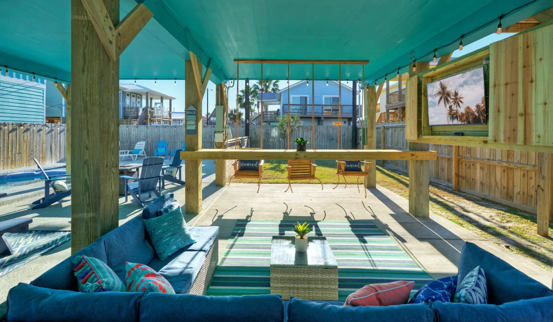 A covered outdoor lounge opens onto a patio with seating and a long counter.