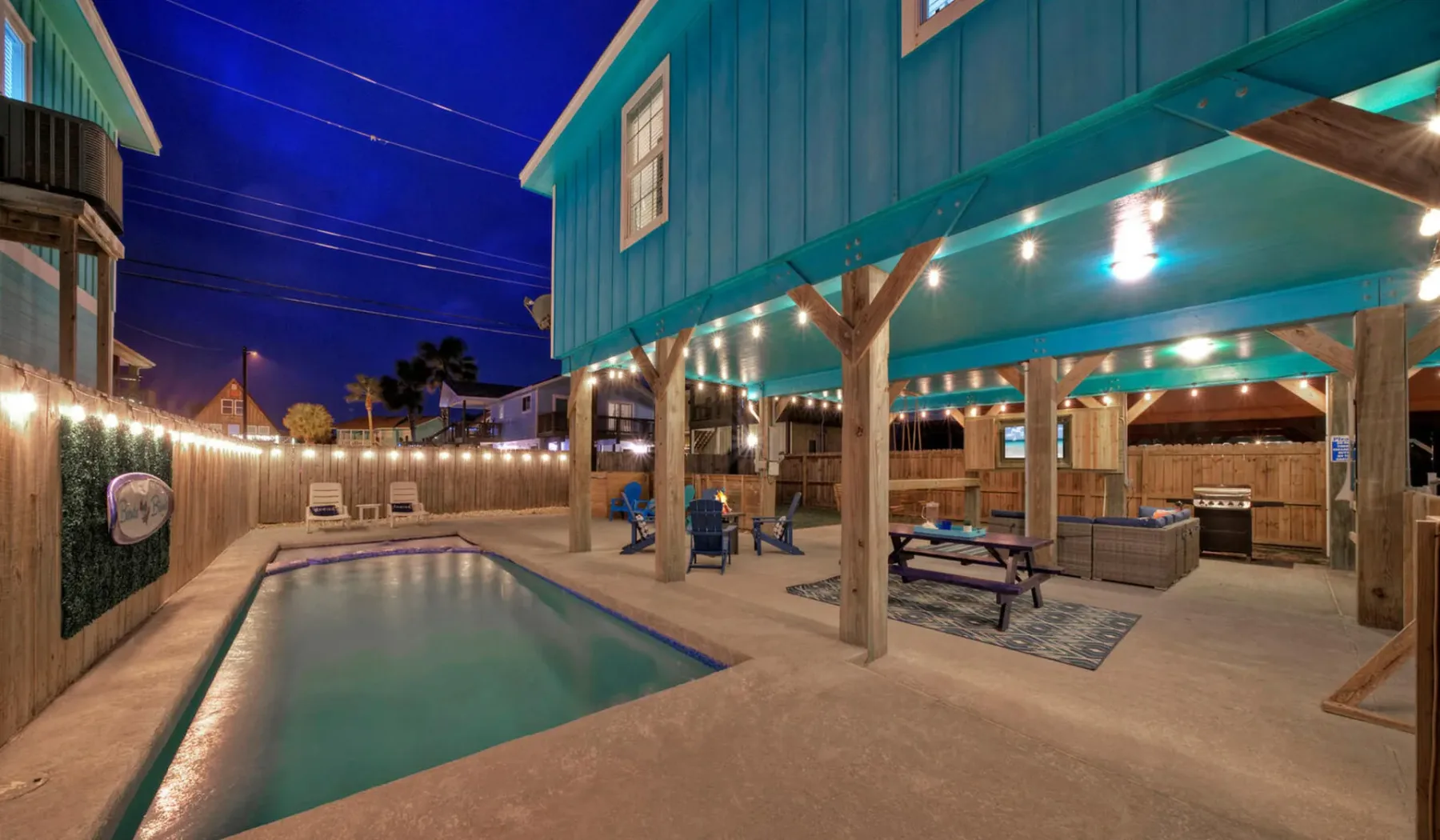 An outdoor pool beside a covered seating area at night.