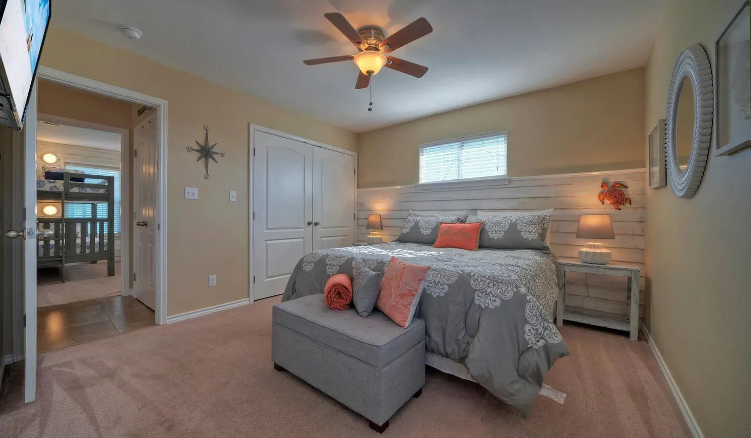 A bedroom with a gray bed, upholstered bench, and bedside tables.