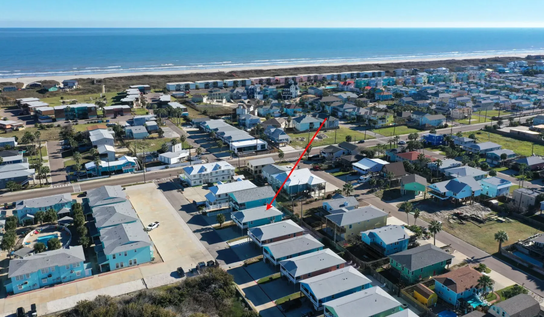 Aerial view of a coastal neighborhood with houses near the ocean.