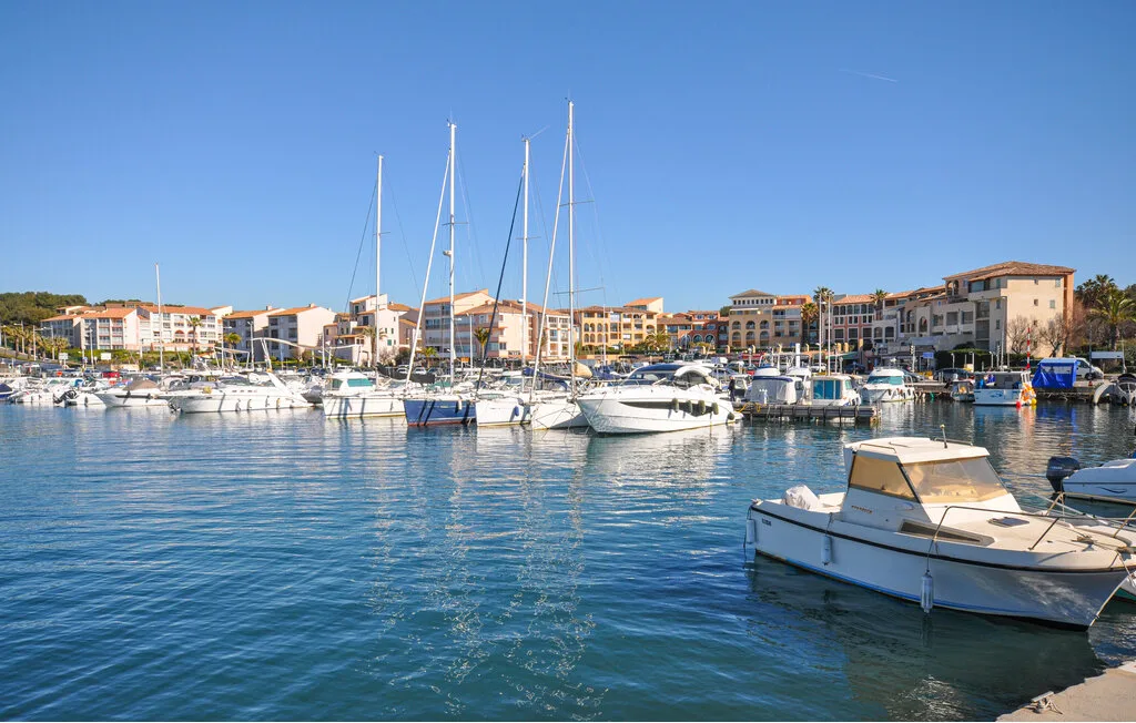 Harbor scene with sailboats and buildings lining the waterfront.