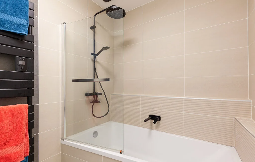 A tiled bathroom with a bathtub and shower.