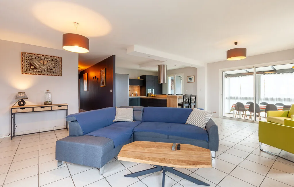 A bright living room with blue seating and a wooden coffee table.