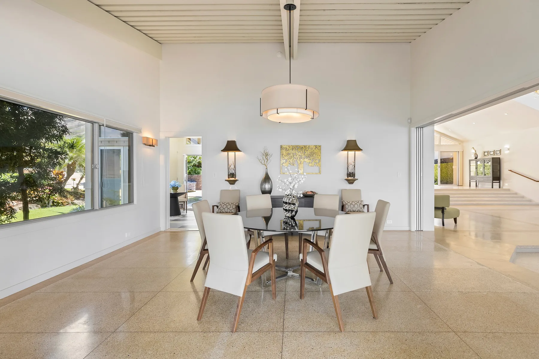 Un comedor luminoso con una mesa y sillas bajo una lámpara colgante.